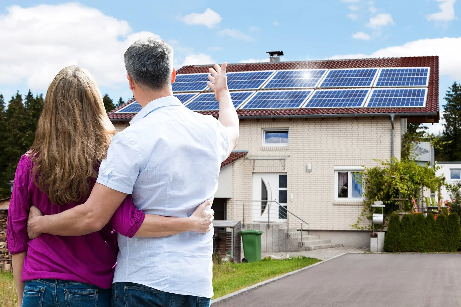 Happy couple viewing their home with solar panels